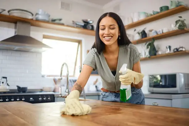 imgi_8_one-smiling-young-mixed-race-woman-wearing-protective-gloves-and-using-a-spray-bottle-with